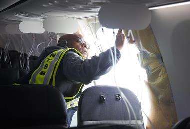 An NTSB investigator examines the Alaska 737 Max 9's after door-plug failure