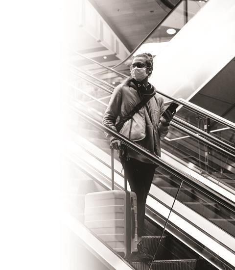 woman-with-a-face-mask-standing-on-an-escalator-3943884