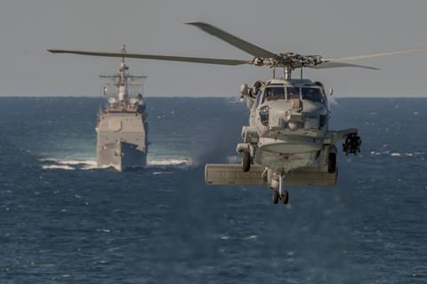 MH-60R Seahawk güdümlü füze kruvazörü USS San Jacinto'nun 2014 c ABD Donanması önünde uçuyor