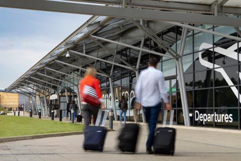 people-wheeling-suitcase-towards-entrance-of-southend-airport