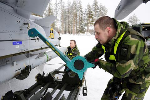 Maintenance personel loading missile on Saab Gripen c Royal Swedish Air Force